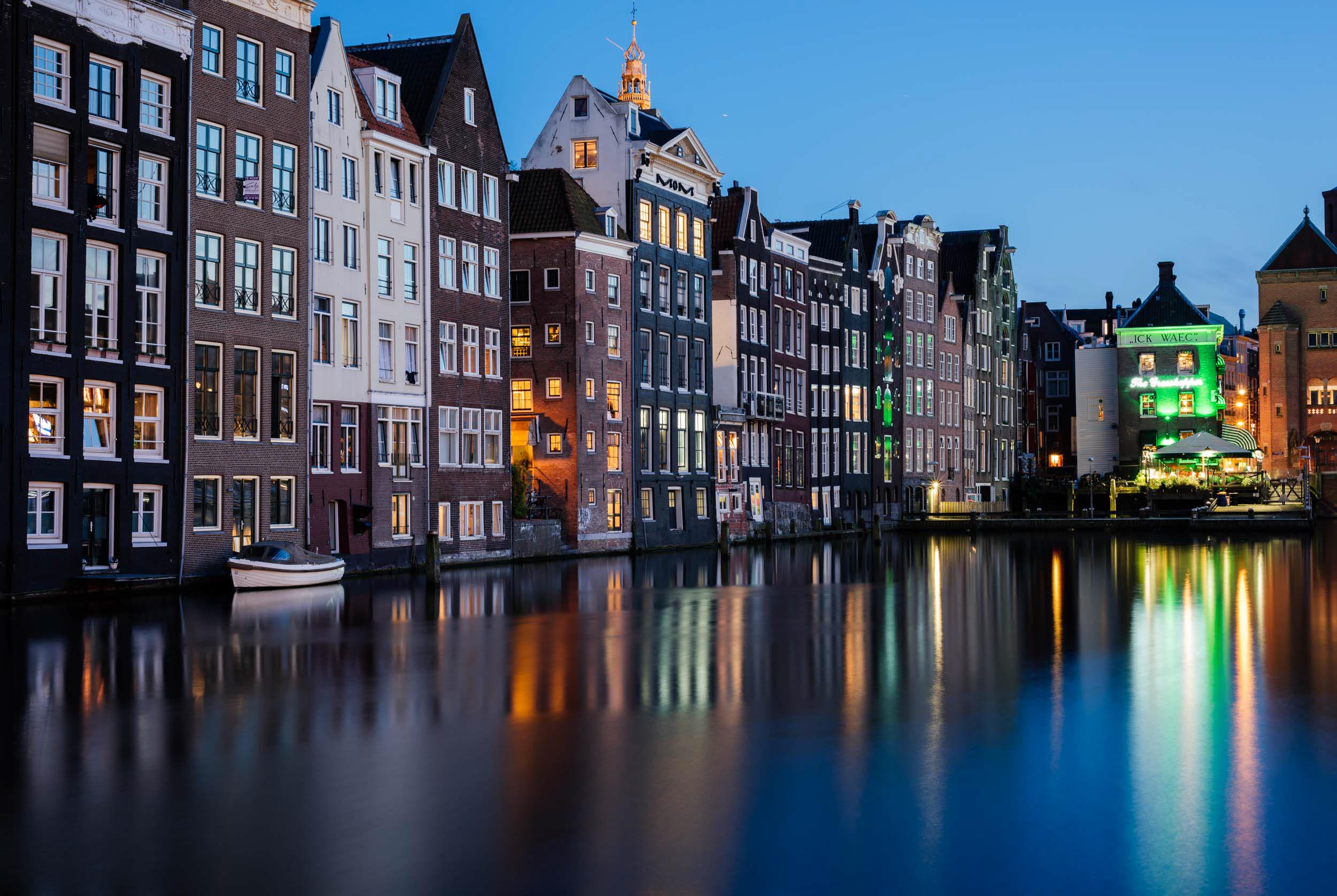 damrak-canal-night-destination-amsterdam-netherlands-holland