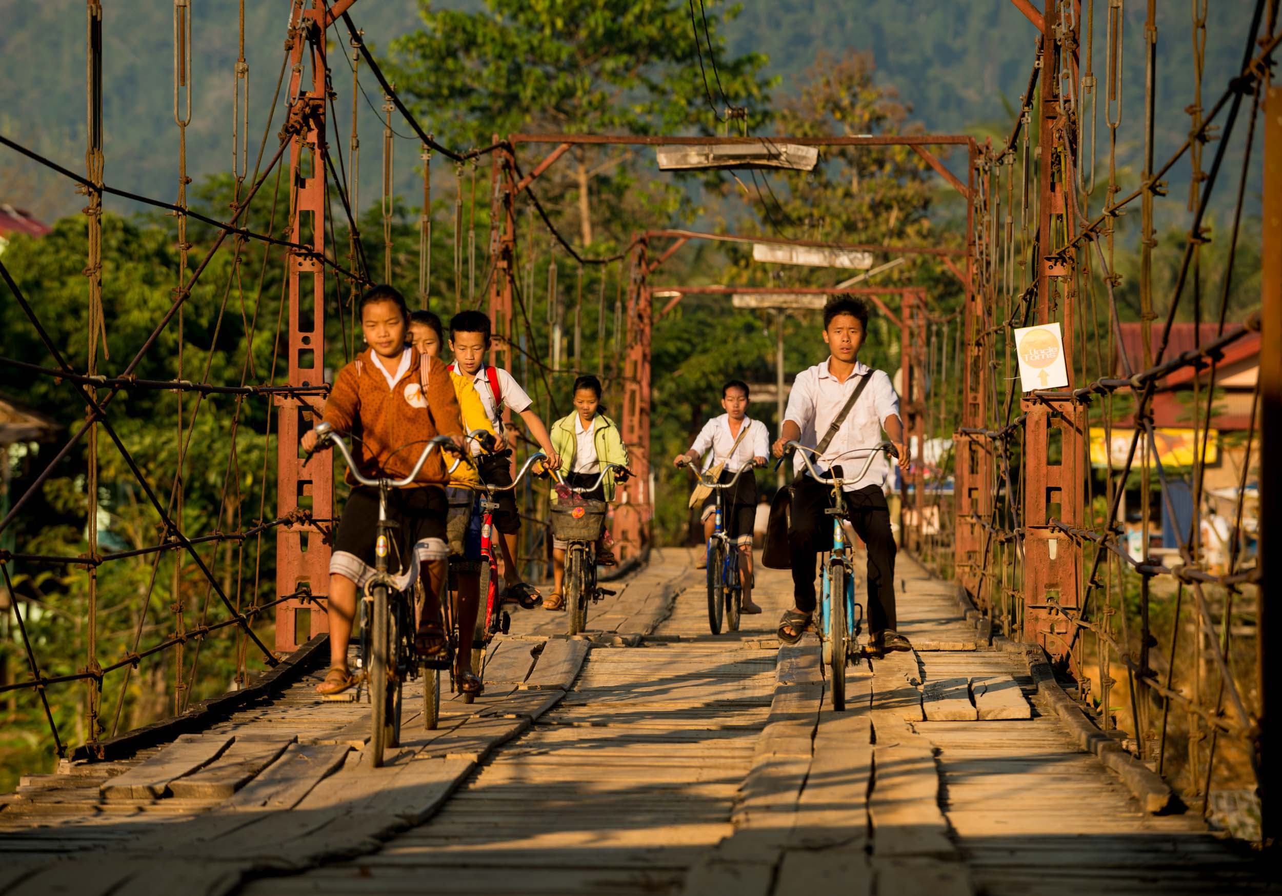 people-local-bicycles-cycling-bridge-vang-vieng-laos-asia